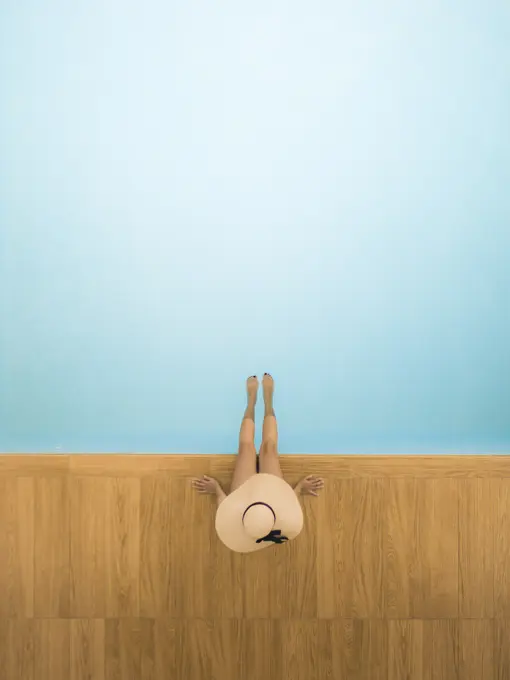 Aerial view of a girl on a poolside, Sicily, Italy.