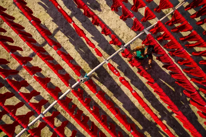 Aerial view of people working in a public laundry draining clothes at sunlight, Araihazar, Dhaka province, Bangladesh.