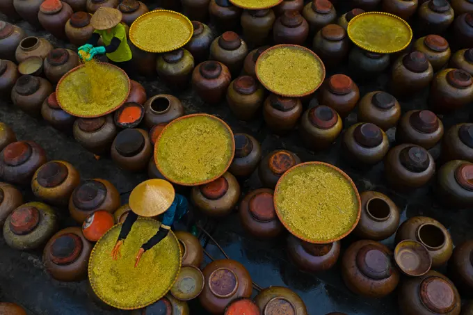 Aerial view of people working in a factory processing Soya source mixing with yellow rice in barrels, Huyện Mỹ Hào, Hung Yen province, Vietnam.