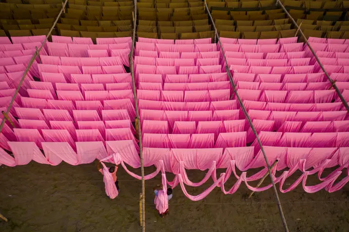 Aerial view of a person working in a public laundry hanging for drying colourful cloth in Narayanganj, Dhaka, Bangladesh.