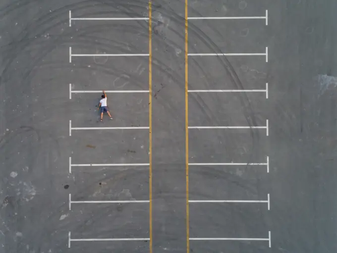 Aerial conceptual view of a man falling from a parking line in Dubai, U.A.E