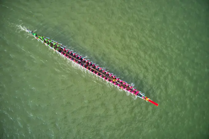 Aerial view of a long canoe for sport activities crossing Meghna river branch near Daudkandi township, Chittagong, Bangladesh.