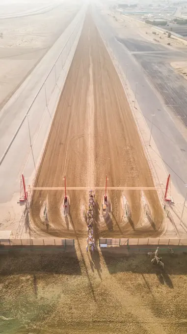 Aerial view of Jockeys and camels on Al Marmoum Camel Racetrack in Dubai, U.A.E.