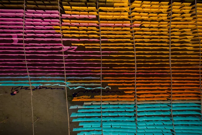 Aerial view of a person working in a public laundry hanging for drying colourful cloth in Narayanganj, Dhaka, Bangladesh.