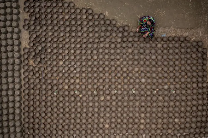 Manikgonj, Bangladesh - 20 February 2022: Aerial view of a woman working with clay pot in Manikgonj, Dhaka, Bangladesh.