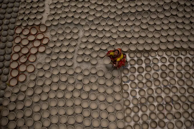 Manikgonj, Bangladesh - 20 February 2022: Aerial view of a woman working with clay pot in Manikgonj, Dhaka, Bangladesh.