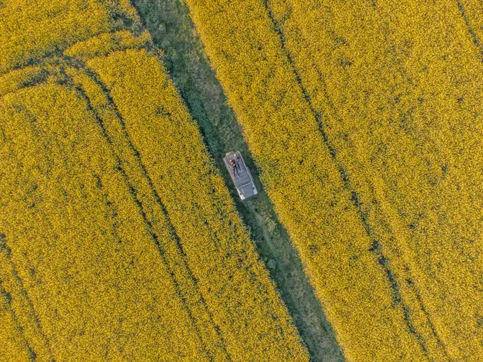 Aerial view of a person relaxing on top of a camper van in La Pera countryside, Girona, Spain.