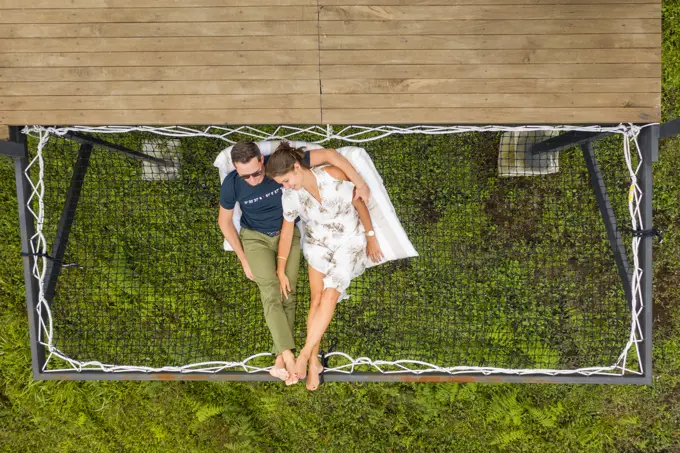 Filandia, Colombia - 08 March 2020: Aerial view of a couple relaxing on a hammock in a campsite, Quindío, Colombia.