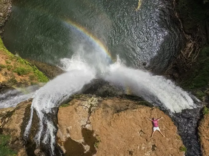 HAWAII - October 15 2016 : Aerial view of a man lying on the top of Wailua falls in Hawaii, USA.