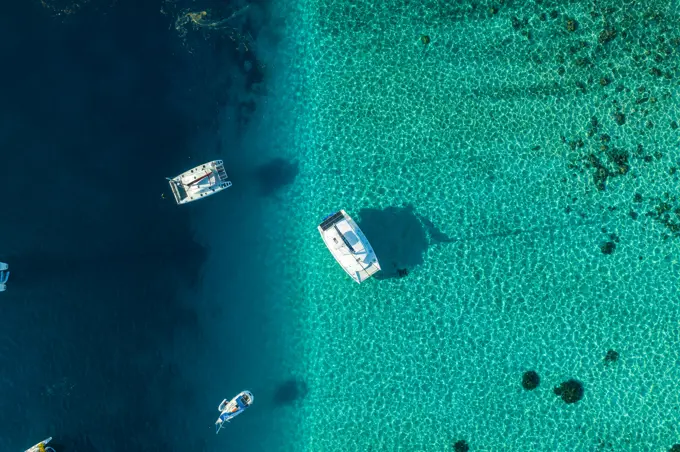 Aerial view of a sailing boat along the reef in Tahiti, French Polynesia.