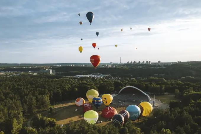 Vilnius, Lithuania - 3 July 2021: Aerial view of hot air balloons taking off from Vingis park and flying over Vilnius in summer time, Lithuania.