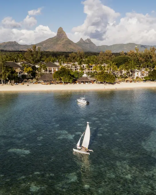 Aerial view of a resort with sailing boat and a mountain range in the background, Flic en Flac, Mauritius.