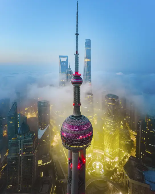 Aerial view of Shanghai Lujiazui tower at sunrise with low fog, China.