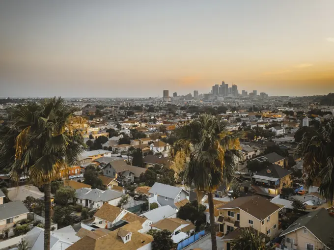 Aerial view of a residential area in California, view of Los Angeles downtown in background at sunset, United States of America.