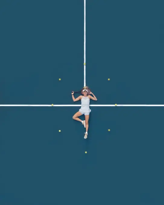 Aerial drone view of a female tennis player laying on a blue tennis court in Melbourne, Victoria, Australia.