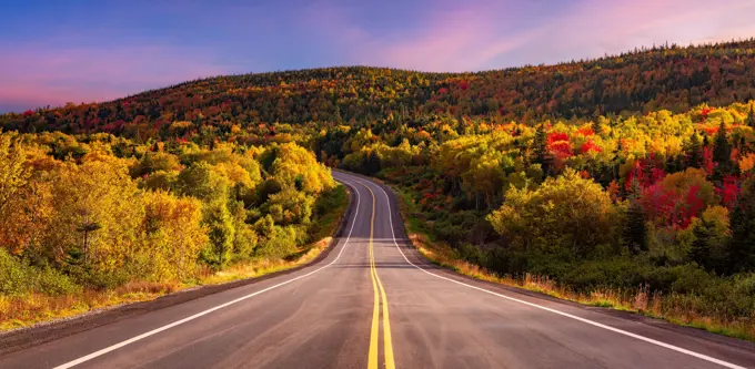 A scenic road in Canadian mountain landscape in autumn at sunrise in Newfoundland, Canada