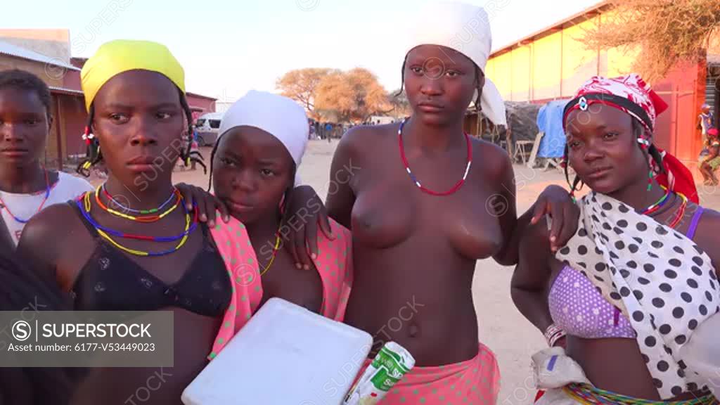 Beautiful topless african tribal women mothers and girls in a Himba tribe region of Opuwo, Namibia. - SuperStock