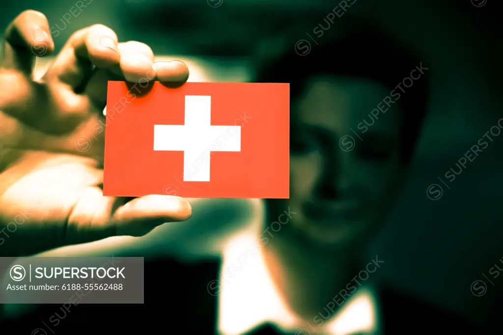 Businessman is holding a business card, flag of Switzerland Businessman is holding a business card, flag of Switzerland Copyright: xZoonar.com/YogeshxMorex 5517875