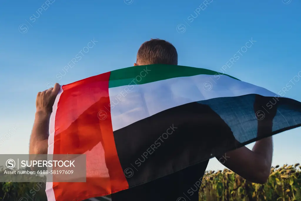 Man holding National Flag Of UAE Waving In The Wind sunset. Flag of United Arab Emirates on Sun Background. Sign of Dubai. Spirit of the Union National Independence Day Man holding National Flag Of UAE Waving In The Wind sunset. Flag of United Arab Emirates on Sun Background. Sign of Dubai. Spirit of the Union National Independence Day or Flag day ,model released, Symbolfoto Copyright: xZoonar.com/AnastasiiaxYanishevskax 21470313 ,model released, Symbolfoto ,property released