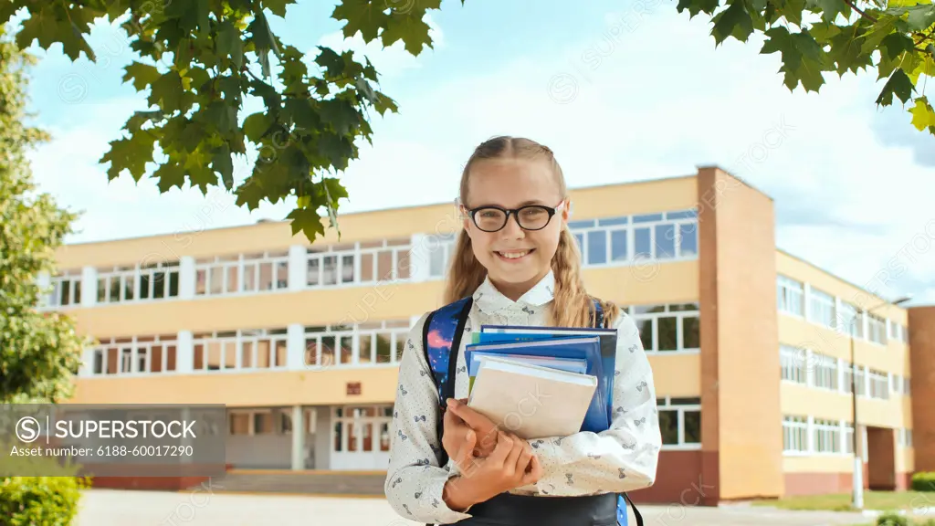 Portrait of smiling school girl child with backpack and books. Portrait of smiling school girl child with backpack and book ,model released, Symbolfoto Copyright: xZoonar.com/MikhailxDavidovichx 14346113 ,model released, Symbolfoto ,property released