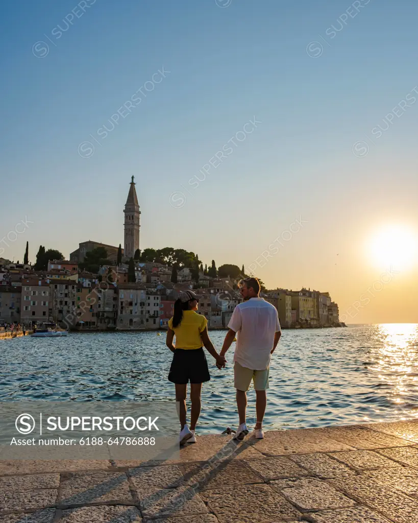 Couple enjoying a romantic sunset stroll along the waterfront in Rovinj, Croatia As the sun sets over Rovinj,Croatia a couple walks hand in hand along the water edge, surrounded by the charm of historic buildings and a peaceful ambiance, capturing a moment of love and tranquility. ,model released, Symbolfoto Copyright: xZoonar.com/FokkexBaarssenx 22288665 ,model released, Symbolfoto ,property released