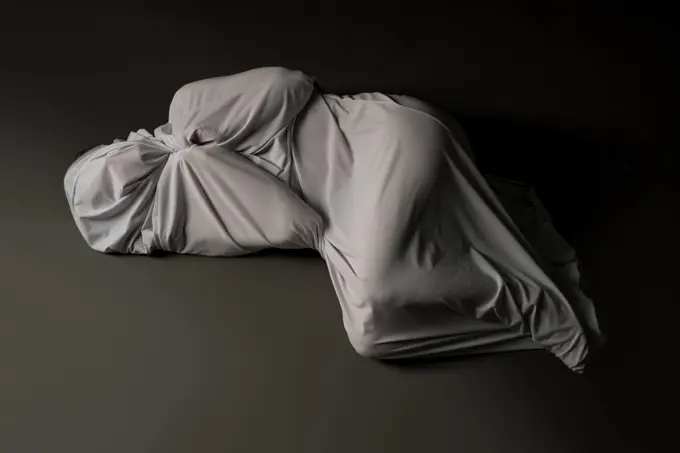 Anonymous person wrapped in cloth lying on floor High angle full body of unrecognizable person wrapped in light gray cloth lying on floor in studio ,model released, Symbolfoto Copyright: xZoonar.com/AndreyxGuryanovx 16576213 ,model released, Symbolfoto ,property released