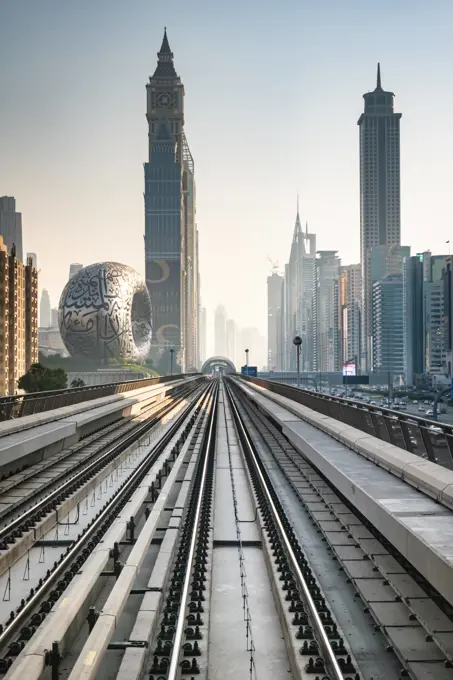 Dubai Metro rail with skyscrapers and Museum of the Future in Dubai in the frame. Dubai, UAE - 11.3.2022: Dubai Metro rail with skyscrapers and Museum of the Future in Dubai in the frame. Dubai Cityscape skyline with modern urban transit system Copyright: xZoonar.com/DaixNtx 21272804