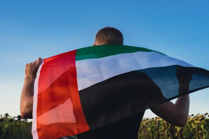 Man holding National Flag Of UAE Waving In The Wind sunset. Flag of United Arab Emirates on Sun Background. Sign of Dubai. Spirit of the Union National Independence Day Man holding National Flag Of UAE Waving In The Wind sunset. Flag of United Arab Emirates on Sun Background. Sign of Dubai. Spirit of the Union National Independence Day or Flag day ,model released, Symbolfoto Copyright: xZoonar.com/AnastasiiaxYanishevskax 21470313 ,model released, Symbolfoto ,property released