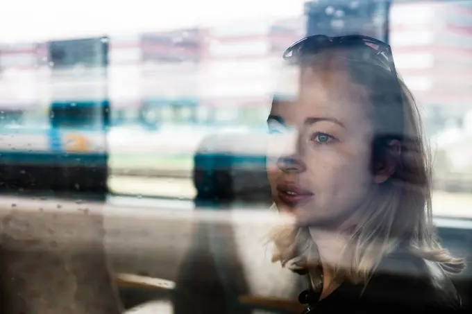 Woman traveler contemplating outdoor view from window of train. Young lady on commute travel to work sitting in bus or train. Woman traveler contemplating outdoor view from window of train. Young lady on commute travel to work sitting in bus or train ,model released, Symbolfoto Copyright: xZoonar.com/MatejxKastelicx 21596810 ,model released, Symbolfoto ,property released