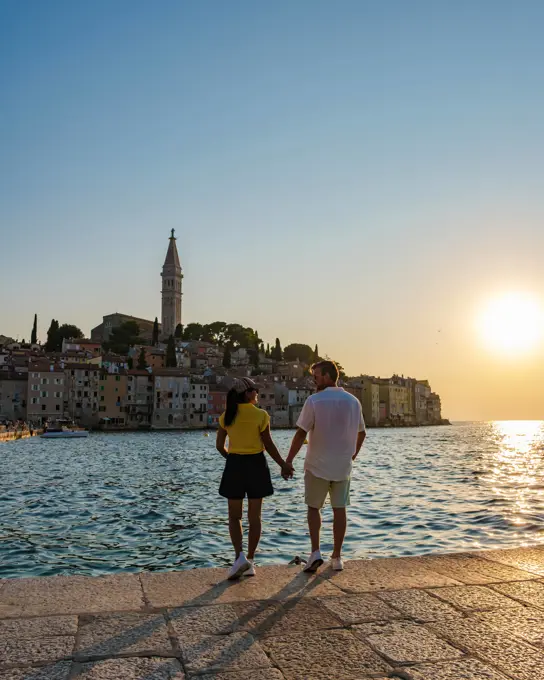 Couple enjoying a romantic sunset stroll along the waterfront in Rovinj, Croatia As the sun sets over Rovinj,Croatia a couple walks hand in hand along the water edge, surrounded by the charm of historic buildings and a peaceful ambiance, capturing a moment of love and tranquility. ,model released, Symbolfoto Copyright: xZoonar.com/FokkexBaarssenx 22288665 ,model released, Symbolfoto ,property released