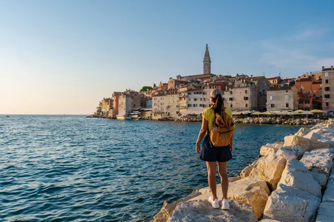 Discovering the enchanting coastline of Rovinj, Croatia at sunset by the Adriatic Sea A traveler gazes at the picturesque town of Rovinj, Croatia, as the sun sets, casting a golden glow over the charming buildings and tranquil waters of the Adriatic Sea. ,model released, Symbolfoto Copyright: xZoonar.com/FokkexBaarssenx 22288798 ,model released, Symbolfoto ,property released