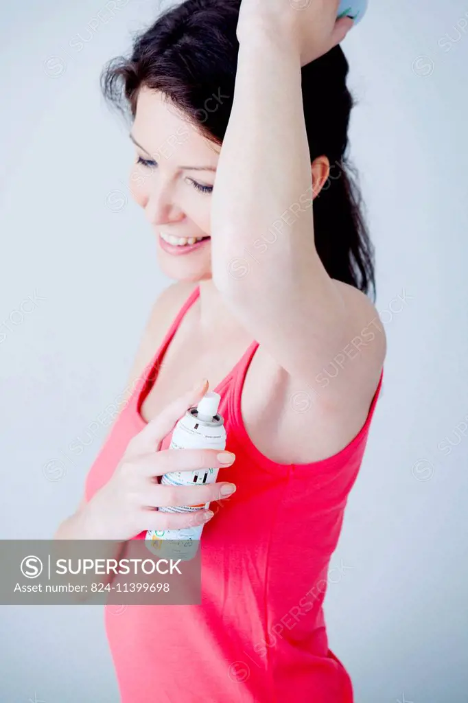 Woman applying deodorant.