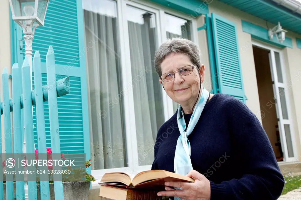 Activities of senior people, reading. She is a volunteer in a media library.