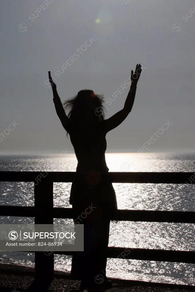 Woman praying at sunset.