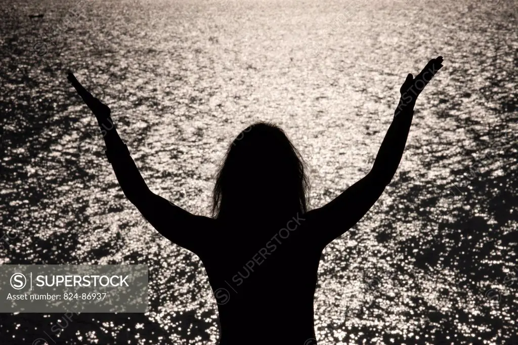 Woman praying at sunset.