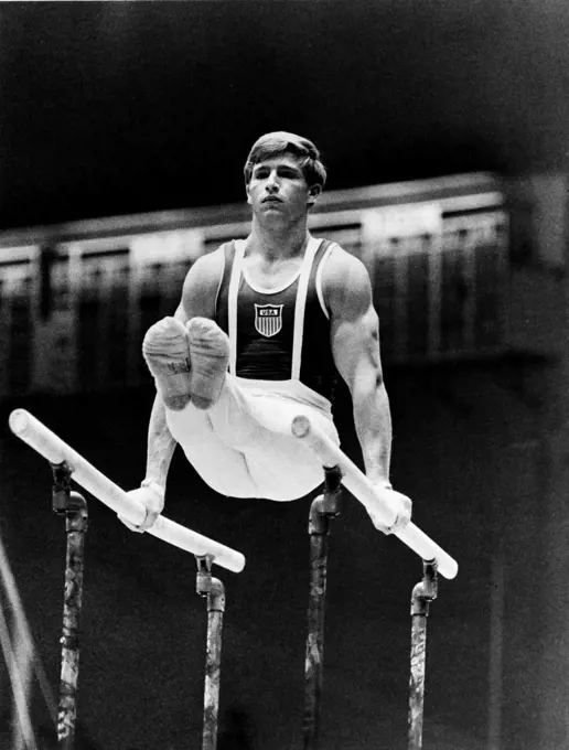 Young man performing on parallel bars at the Olympic games